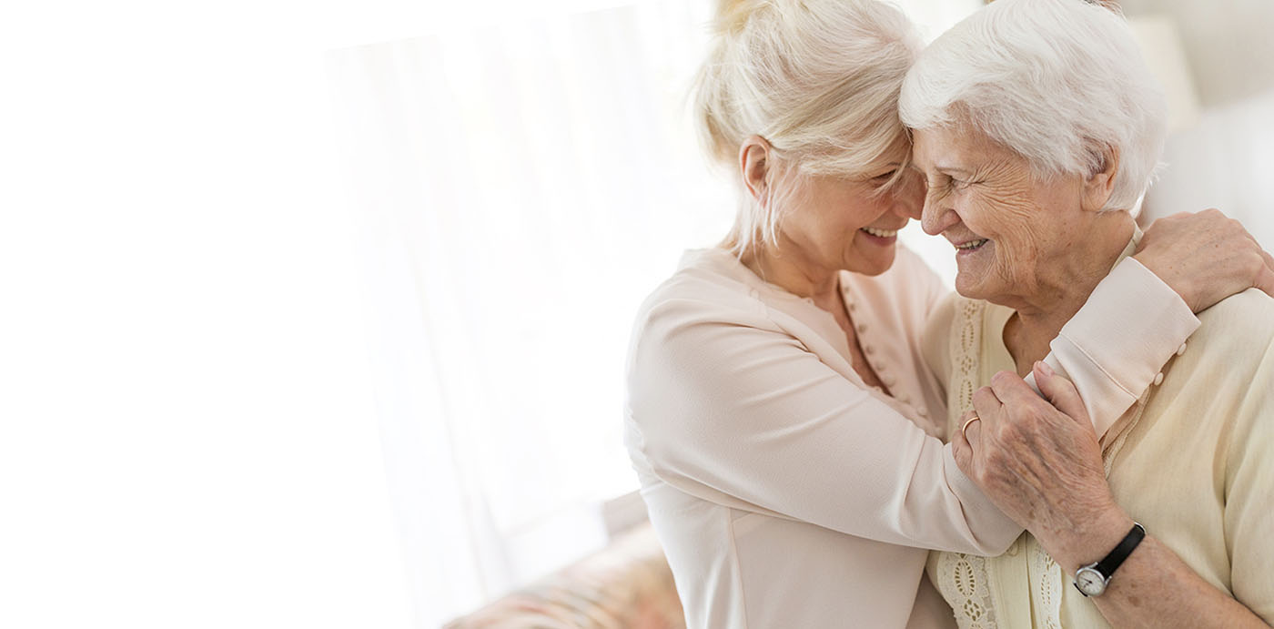 daughter embracing senior mother